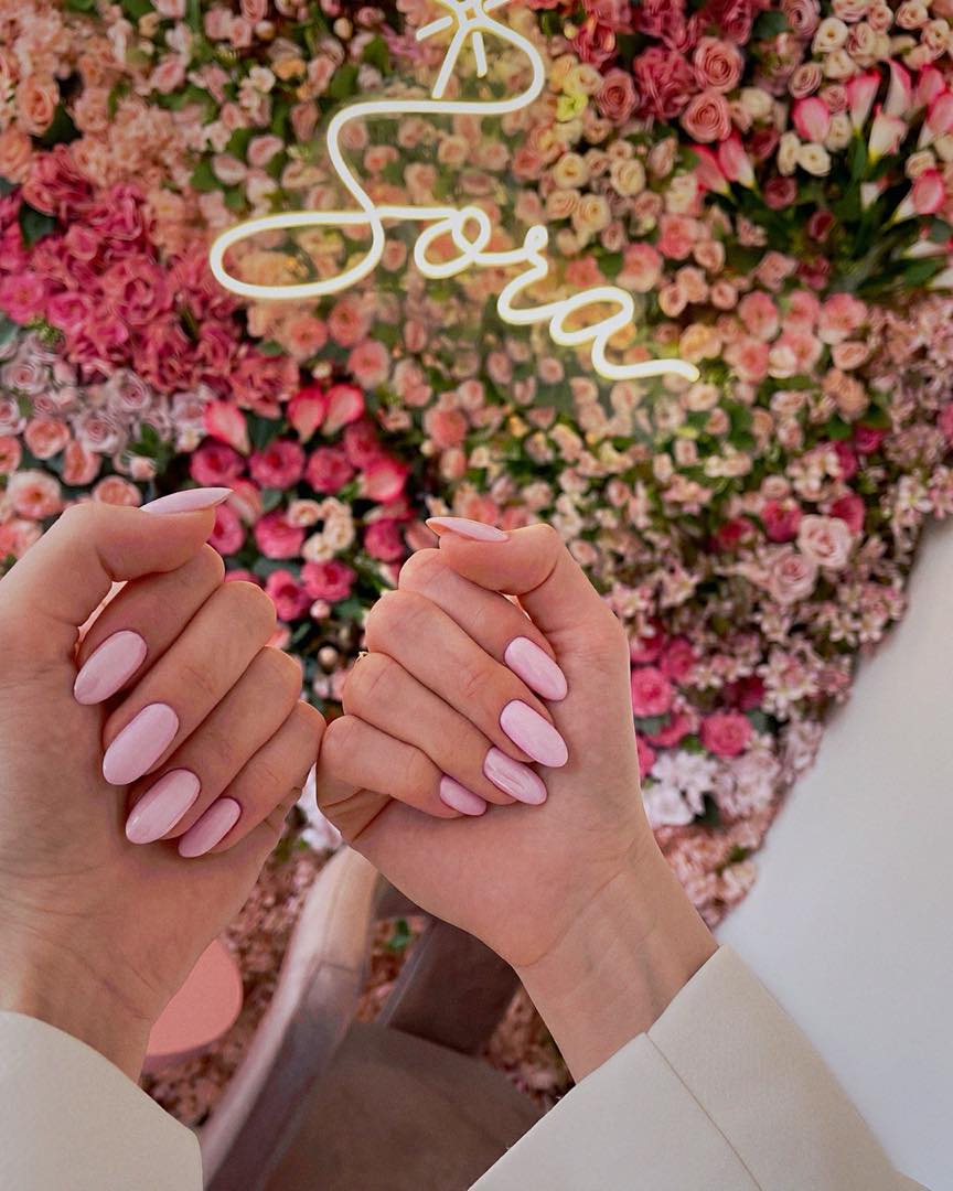 Sora Beauty Studio çiçek duvarı ve neon logosu önünde pastel pembe badem kalıcı oje — Suadiye